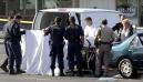 Authorities hold up white sheets as the body of multiple-murder suspect James Ferguson, is loaded into a van in Rancho Cordova, Calif., Monday, Sept. 10, 2001. Ferguson, 20, killed himself after leading officers on a 40-minute chase through the area. Ferguson was wanted for allegedly killing four people late Saturday night and another person Sunday. He was spotted in a stolen car Sunday night and pursued, eventually losing control of the car, crashing into a light pole. Ferguson then exchanged shots with police and after being wounded shot himself to death. (AP Photo/Rich Pedroncelli)