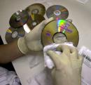 A Netflix worker cleans off their recently returned DVD rental, 'The Ten Commandments' at their distribution plant in San Jose, Calif., Monday, Sept. 10, 2001. Online DVD rental company Netflix is emerging as one of the Internet's rising stars that has attracted a cast of 300,000 subscribers who pay a $19.95 monthly fee to get up to three DVD rentals mailed to them. (AP Photo/Paul Sakuma)