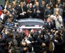 Media people try to take a picture of member of DaimlerChrysler board Juergen Hubbert and F1 drivers David Coulthard and Mika Hakkinen standing next to the new Mercedes SL 55 AMG cabriolet during media day of the International Auto Show (IAA) in Frankfurt, Germany, on Tuesday, Sept. 11, 2001. The show will be open to the public starting Thursday. (AP Photo/Michael Probst)