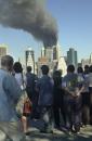 Spectators watch the burning World Trade Center towers from the Brooklyn Promende, across the East River from Manhattan Tuesday, Sept. 11, 2001, in New York. (AP Photo/Kathy Willens)