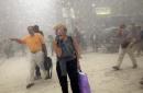 People run from the collapse of World Trade Center Tower  Tuesday, Sept. 11, 2001 in New York. In a horrific sequence of destruction, terrorists hijacked two airliners and crashed them into the World Trade Center in a coordinated series of attacks that brought down the twin 110-story towers. (AP Photo/Suzanne Plunkett)