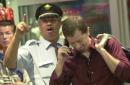 Patrick Louison, a Skycap, in background, reacts to the television image of the South World Trade Center collapsing Tuesday, Sept. 11, 2001, as an unidentified man breaks down as he talks to his family upon arrival at Miami International Airport. (AP Photo/Marta Lavandier)