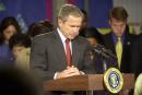 President Bush observes a moment of silence with a crowd of educators and students at Emma E. Booker Elementary School on Tuesday, Sept. 11, 2001, in Sarasota, Fla. The president had just told the group about the New York City disaster. He then quickly returned to Washington. (AP Photo/Nicole Fruge, Pool)