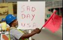 Brenda Jackson-Gray, of Chicago, a flagger with A&L Construction on the Chicago Skyway, holds a sign Tuesday, Sept. 11, 2001, that she made with lipstick and a foam construction board to express her feelings about the attacks in New York and Washington, Tuesday morning. Jackson-Gray said she was filled with a feeling 'overwhelming sadness' about the events of the day. (AP Photo/Ted S. Warren)