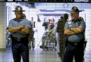 Two Massachusetts State Police troopers stand in front of the closed entrance to American Airlines gate area as passengers are evacuated, rear, at Logan International Airport in Boston, Tuesday, Sept. 11, 2001. American Airlines confirmed two of its planes were hijacked and crashed into the World Trade Center. American said the flights were Flight 11, a Boeing 767 en route from Boston to Los Angeles and Flight 77, a Boeing 757 operating from Washington Dulles to Los Angeles. (AP Photo/Michael Dwyer)