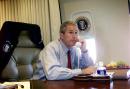 President Bush watches television as he talks on the phone with New York Mayor Rudy Guiliani and Gov. George Pataki aboard Air Force One during a flight following a statement about the terrorist attack on the World Trade Center in New York City, Tuesday, Sept. 11, 2001. (AP Photo/Doug Mills)