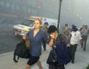 People cover their faces from the shower of dust and debris as they leave the area of the attack on New York's World Trade Center, Tuesday Sept. 11, 2001.  Terrorists crashed two hijacked airliners into the World Trade Center and brought down the twin 110-story towers Tuesday morning. (AP Photo/Richard Drew)