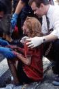 Emergency workers help a women after she was injured in the terrorist attack on the World Trade Center in New York, Tuesday, Sept. 11, 2001. (AP Photo/Gulnara Samiolava)