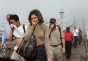 People cover their faces as they move across the Brooklyn Bridge out of the smoke and dust in Manhattan Tuesday Sept. 11, 2001, after a terrorist attack on the twin towers of the World Trade Center.  Terrorists hijacked two airliners and crashed them into the World Trade Center in a coordinated series of blows that brought down the twin 110-story towers.  (AP Photo/Daniel Shanken)