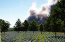 A cloud of smoke rises from the Pentagon, background, at Arlington National Cemetery, Va., Tuesday, Sept. 11, 2001. The Pentagon took a direct, devastating hit from an aircraft and the enduring symbols of American power were evacuated as an apparent terrorist attack quickly spread fear and chaos in the nation's capital. (AP Photo/Patricia Brundick)