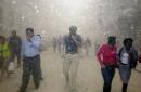 People run from the collapse of World Trade Center towers in New York, Tuesday, Sept. 11, 2001. Mounting an audacious attack against the United States, terrorists crashed two hijacked airliners into the World Trade Center and brought down the twin 110-story towers. (AP Photo/Suzanne Plunkett)