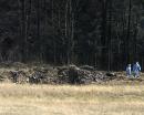 Inspectors walk around the wreckage of a United Airlines plane in a field near Shanksville, Pa., Tuesday, Sept. 11, 2001. The jetliner carrying 45 people crashed into a grassy field Tuesday morning, moments after a man who said he was a passenger told an emergency dispatcher in a cell phone call: ``We are being hijacked, we are being hijacked!'' (AP Photo/Kalim A. Bhatti)