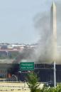 The Washington Monument is seen through smoke as the Pentagon burns after a direct, devastating hit from an aircraft Tuesday, Sept. 11, 2001. (AP Photo/Linda Spillers)