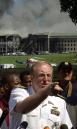 With smoke still billowing at the Pentagon in the background, Navy Rear Adm. Craig Quigley talks to reporters in Washington, Tuesday, Sept. 11, 2001. The Pentagon was damaged by a direct hit from an aircraft Tuesday. (AP Photo/Steve Helber)