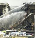 Firefighters spray water on a section of the Pentagon Tuesday, Sept. 11, 2001 after the building tokk a direct hit by an aircraft. (AP Photo/Steve Helber)