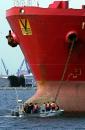 U.S. Coast Guard personnel, Customs officers and others inspect the hull of the Netherlands-registered tanker Iver Example, being held at anchor with other ships outside the breakwater off the ports of Long Beach and Los Angeles, Tuesday, Sept. 11, 2001, off Long Beach, Calif. The port was closed to all incoming ships following coordinated attacks on U.S. facilities in New York and elsewhere in the United States.  (AP Photo/Reed Saxon)