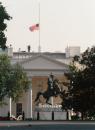 The White House American flag flies at half-staff as members of the security detail stand on the roof, in Washington, Tuesday, Sept. 11, 2001, following terrorist attacks on Washington and New York. (AP Photo/Kamenko Pajic)