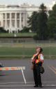 With the White House in the background, a uniformed Secret Service agent, holding a pump shotgun, searches the sky Tuesday, Sept. 11, 2001, after apparent terrorist attacks in New York and at the Pentagon. (AP Photo/Evan Vucci)