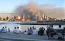 From Sinatra Park in Hoboken, NJ, people sit and look across the Hudson River at the sunset reflecting on buildings in lower Manhatten, Tuesday, September 11, 2001. The World Trade Center was levelled after two planes controlled by terrorists crashed in to the landmark. (AP Photo/ Stuart Ramson)