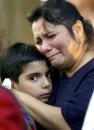 Debra Garcia clutches her son M. Jay Garcia, 9, during an inter-faith prayer vigil in San Antonio, Tuesday, Sept. 11, 2001, held for the victims of Tuesday morning's terrorist attacks at the World Trade Center and at the Pentagon. (AP Photo/Eric Gay)