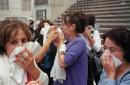 People hold towels to their faces and put on masks for protection from the smoke and dust from the collapse of the twin towers at the World Trade Center in New York Tuesday, Sep. 11, 2001. Terrorists crashed two passenger jets into the twin towers causing them to collapse. (AP Photo/Richard Cohen)