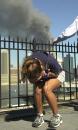 A woman standing on the Promenade in Brooklyn, N.Y., which presents a view of the Manhattan skyline, reacts to a third explosion at the World Trade Center in New York, Tuesday, Sept. 11, 2001. (AP Photo/Kathy Willens)