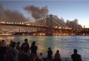 Spectators along the Brooklyn shore look toward Manhattan as smoke billows from the World Trade Center after terrorists crashed two hijacked airliners into the 110-story twin towers Tuesday, Sept. 11, 2001. New York's Williamsburgh Bridge is in the foreground. (AP Photo/Ron Frehm)