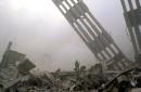 Firefighters are dwarfed by debris at the site of the World Trade Center in New York Tuesday, Sept. 11, 2001. Planes crashed into the upper floors of the World Trade Center towers minutes apart Tuesday morning collapsing both 110-story buildings. (AP Photo/Graham Morrison)