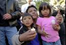 Freddie DeLeon, center, and his children, Alddie DeLeon, left, 3, and Fredelice, right, 5, listen to speeches for peace and rememberance during a candlelight vigil Tuesday, Sept. 11, 2001, in San Francisco, for victims of the terrorist attacks in New York City and Washington, D.C. (AP Photo/Julie Jacobson)