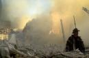 A lone firefighter moves through piles of debris at the site of the World Trade Center in New York,Tuesday, Sept. 11, 2001. Two Planes crashed into the upper floors of the World Trade Center towers minutes apart Tuesday morning, collapsing both 110-story buildings. (AP Photo/Graham Morrison)