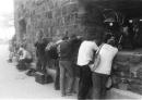 People take shelter against a wall in Battery Park in New York, Tuesday, Sept. 11, 2001, to escape the smoke, dust and ashes from the collapse of the World Trade Center. Terrorists crashed two hijacked passenger jets into the twin towers causing them to collapse. (AP Photo/Om Rupani)