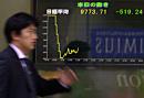 A businessman passes by a Tokyo brokerage's electric board indicating the chart of Tokyo main stock index's sharp plunge, breaking the key 10,000-point mark for the first time in 17 years, Wednesday, Sept. 12, 2001 as traders dumped shares in reaction to terrorist attacks in New York City and Washington.  The benchmark 225-issue NIkkei Stock Average fell 519.24 points, or 5.04 percent, to end the morning session at 9,773.71. (AP Photo/Katsumi Kasahara)