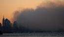 A cloud of smoke covers lower Manhattan at sunrise Wednesday, Sept. 12, 2001, in this view seen from the Staten Island borough of New York. Two highjacked aircrafts crashed into the World Tade Center Tuesday, collapsing the 110-story twin towers. (AP Photo/Chad Rachman)