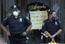 Police officers stand outside a restaurant near the site of the World Trade Center Wednesday Sept. 12, 2001, as rescue efforts continue following the terrorist attack on the twin towers.  The restaurant has a hand-lettered sign calling for President Bush to declare war. (AP Photo/Amy Sancetta)