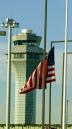 The U.S. flag flies at half-staff in front of the tower at Chicago's O'Hare Airport Wednesday, Sept. 12, 2001. O'Hare, along with the rest of the country's airports, remain closed due to the terrorist attacks Tuesday. (AP Photo/Charles Bennett)