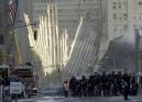 Workers gather Wednesday, Sept. 12, 2001, to continue work at the site of the attack on the World Trade Center in New York.  A large piece of the facade fallen from the one of the twin towers is in the background. (AP Photo/Amy Sancetta)