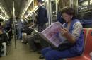 Riding the New York subway, Teresa Sanchez of the Queens borough reads the New York Daily News Wednesday morning Sept. 12, 2001 for accounts of Tuesday's terrorist attacks against the World Trade Center and the Pentagon. Ridership was much lighter than usual after the authorities asked non-essesential workers to stay home and closed city schools. (AP Photo/Matt Moyer)