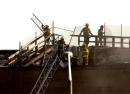 Firefighters carry ladders up to the roof of the Pentagon as they continue to fight small fires in Washington, DC., Wednesday Sept. 12, 2001. A hijacked airliner flew into the structure on Tuesday.  (AP Photo/Steve Helber)