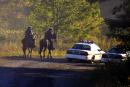 Police on horseback and in cars move along an access road to the site of a downed commercial jet Wednesday  Sept. 12, 2001 that crashed near Shanksville, Pa., Tuesday.  United Airlines Flight 93 from Newark to San Francisco, a Boeing 757, slammed into a grassy field about 80 miles southeast of Pittsburgh after being hijacked. (AP Photo/Gary Tramontina)