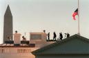 With the Washington Monument, left, in the background and the American flag at half-staff, a security detail stands on the roof of the White House Wednesday, Sept. 12, 2001 a day after terrorist attacks at the Pentagon and New York's World Trade Center. (AP Photo/Kamenko Pajic)