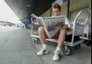 Mike Pendersen, of Minneapolis, reads a newspaper as he waits for a flight home outside the locked doors at Hartsfield Atlanta International Airport Wednesday, Sept. 12, 2001. Hartsfield was closed after air travel was suspended in the United States following  terrorist attacks in New York and Washington Tuesday. (AP Photo/John Bazemore)