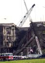 Cranes and other heavy equipment move into position to remove debris from the damaged area of the Pentagon, Wednesday, Sept. 12, 2001. A hijacked airliner flew into the structure on Tuesday. (AP Photo/Steve Helber)