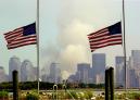 Flags fly at half-staff in Bayonne, N.J., as smoke rises from lower Manhattan following the collapse of both towers of the World Trade Center in New York, Wednesday, Sept. 12, 2001.  Two hijacked commercial aircraft crashed into the center's towers Tuesday. (AP Photo/Charles Krupa)