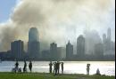 Spectators watch from Jersey City, N.J. as smoke rises from lower Manhattan and debris of the World Trade Center in New York, Wednesday Sept. 12, 2001.  Two hijacked commercial aircraft crashed into the center's towers Tuesday. (AP Photo/Charles Krupa)