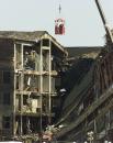 Officials working from a basket inspect areas of the Pentagon Wednesday, Sept. 12, 2001, as they work to put out all of the fires caused by a hijacked airliner that crashed into the building Tuesday. (AP Photo/Ron Edmonds)