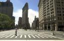 A woman crosses a nearly empty intersection in New York, Wednesday, Sept. 12, 2001. Dust rises in the background, to the right of the Flat Iron Building,center, where the World Trade Center once stood. Two hijacked airliners crashed  into the  towers on Tuesday, Sept. 11, destroying both buildings. (AP Photo/Robert F. Bukaty)