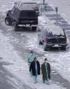 Medical personel walk past dust covered cars near the site of the World Trade Center in New York, Wednesday, Sept. 12, 2001.  In the most devastating terrorist onslaught ever waged against the United States, knife-wielding hijackers crashed two airliners into the World Trade Center on Tuesday, toppling its twin 110-story towers.(AP Photo/ Beth A. Keiser)