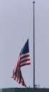 A large United States flag is lowered to half staff atop a downtown San Diego office building September 11, 2001 after three hijacked planes crashed into major U.S. landmarks destroying both of New York's World Trade Center  towers, and hitting the Pentagon in Washington, plunging the United States into unprecedented chaos and panic.                        REUTERS/ Mike Blake