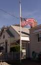 An American flag flies at half-staff fronting a home in Seattle, Washington on September 11, 2001 after the World Trade Centers in New York City and the Pentagon in Washington, D.C. were attacked. In the worst attack on American soil since Pearl Harbor, three hijacked planes slammed into the Pentagon and New York's landmark World Trade Center on Tuesday, demolishing the two 110-story towers that symbolize U.S. financial might.  The attacks brought normal life across the United States to a standstill, turning the major cities of the nation into eerie ghost towns. All financial markets were closed, millions of workers sent home early, all flights around the nation were canceled and all airports shut in an unprecedented move. REUTERS/Anthony P. Bolante