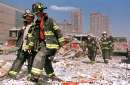 New York City firefighters wear face masks as they prepare to join other firefighters in battling blazes and helping injured people after the World trade Center buildings collapse September 11, 2001.  Three hijacked planes slammed into the Pentagon and New York's landmark World Trade Center on Tuesday, demolishing the two 110-story towers that symbolize U.S. financial might.     REUTERS/Anthony Correia